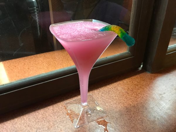 The mocktail is garnished with a gummy worm!